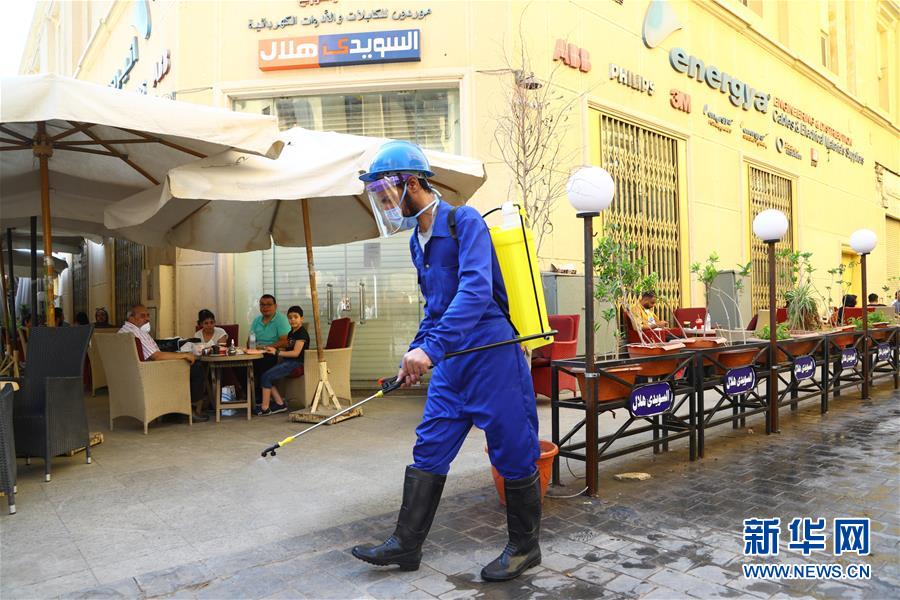 6月27日，工作人员在埃及首都开罗商业区消毒。 自27日起，埃及解除部分防控措施。全国范围的宵禁时间调整为每日零时至4时，允许餐厅、咖啡馆、电影院以25%的运营能力开放并营业至22时，允许商店营业至21时。 新华社发（艾哈迈德·戈马摄）