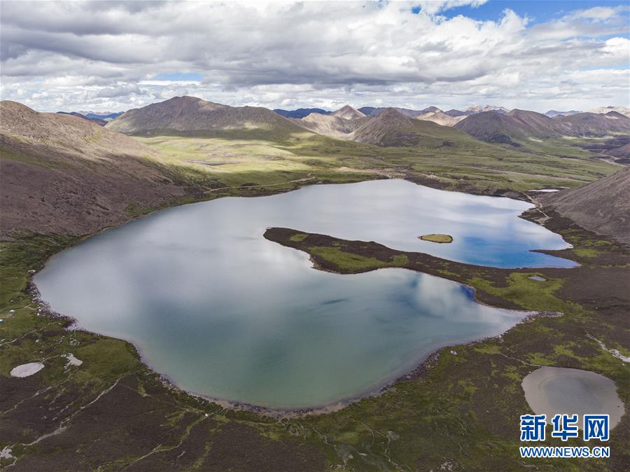 这是6月26日拍摄的思金拉错（无人机照片）。 思金拉错湖位于西藏拉萨市墨竹工卡县，四周群山高耸，湖面海拔约4500米。每年春夏两季，湖畔山花遍地、绿草如茵，吸引不少游客。 新华社记者孙非摄