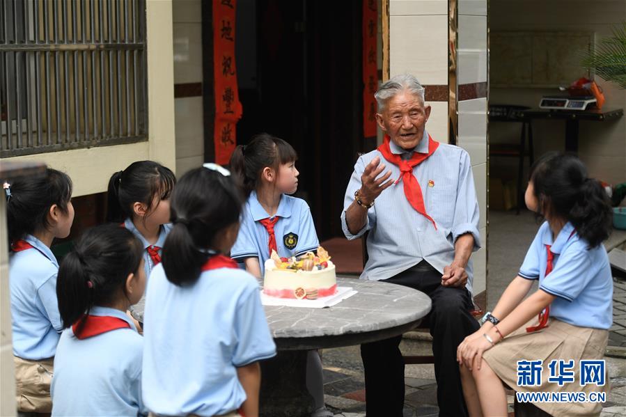 6月28日，吴兴区第一小学学生聆听八里店镇前村村老党员陈金茂（右二）讲故事。 临近“七一”，浙江省湖州市吴兴区八里店镇组织小学生开展“童心向党”主题绘画、聆听老党员讲故事、参观红色教育基地等活动。 新华社记者黄宗治摄