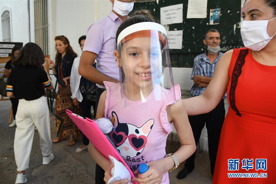 6月29日，一名戴防护面罩的考生在突尼斯首都突尼斯市准备参加考试。新华社发（阿代尔摄）