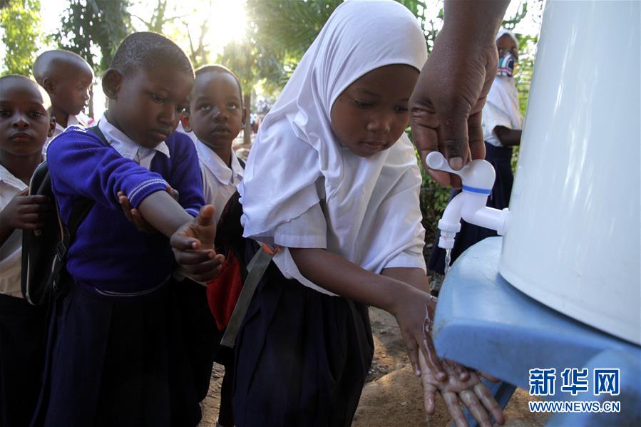 6月29日，学生们在坦桑尼亚达累斯萨拉姆一所小学上课前排队洗手。新华社发