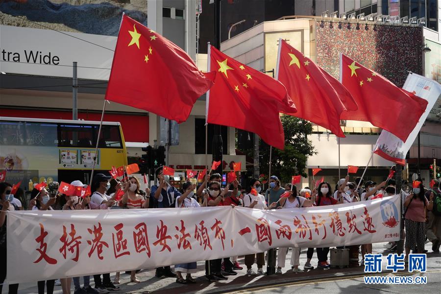 6月30日，香港市民在铜锣湾街头支持实施香港国安法。 当日，十三届全国人大常委会第二十次会议表决通过《中华人民共和国香港特别行政区维护国家安全法》，并决定将该法列入香港基本法附件三，由香港特别行政区在当地公布实施。 新华社记者 王申 摄