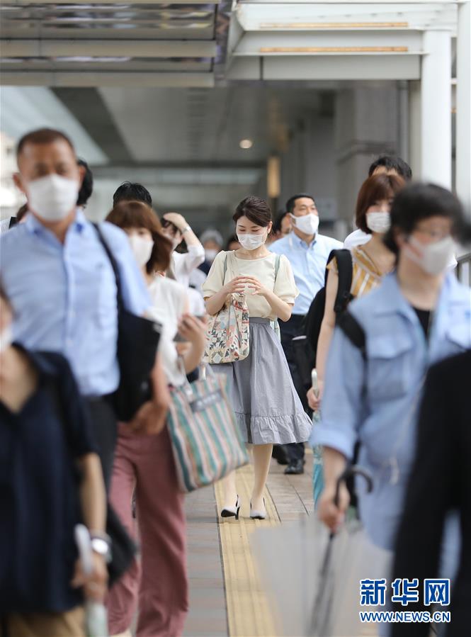 6月30日，在日本东京品川，人们下班后离开写字楼走向车站。新华社记者 杜潇逸 摄
