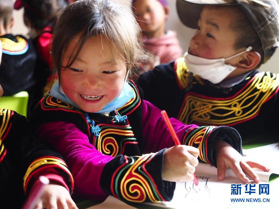 在凉山州昭觉县尼地乡七里坝社，5岁的女孩土比尔坐在幼教点画画（6月18日摄）。 新华社记者 王迪 摄