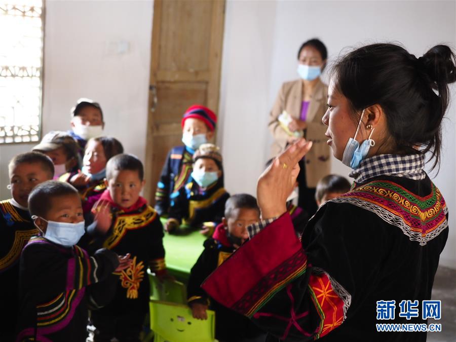 在凉山州昭觉县尼地乡七里坝社，28岁的村级幼教点辅导员俄尔日且（右一）用普通话和孩子们对话，教他们做手指游戏（6月18日摄）。 新华社记者 王迪 摄