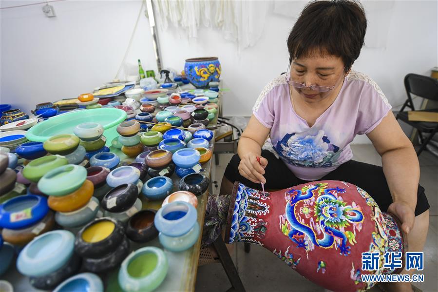 7月1日，河北省香河县景泰蓝制品厂的工作人员在对景泰蓝工艺品进行掐丝。 近来，河北省香河县景泰蓝企业全面复工复产，并积极通过互联网线上洽谈海外订单，工人加紧生产，供应市场。 新华社记者 李晓果 摄