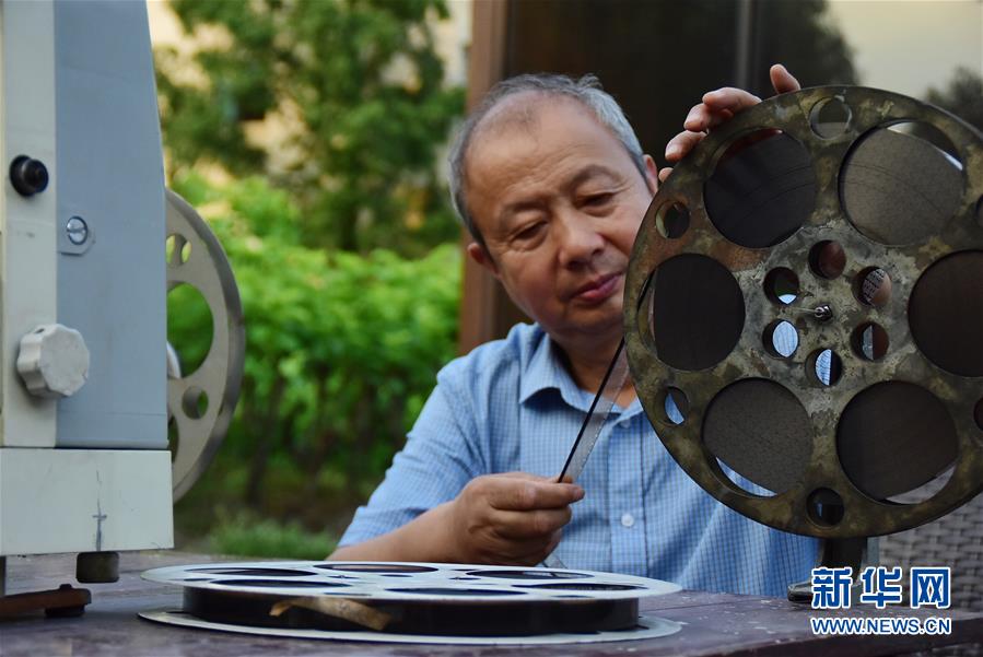 6月30日，朱生荣在当晚电影开播前将胶片调至起始帧。新华社记者 郑梦雨 摄