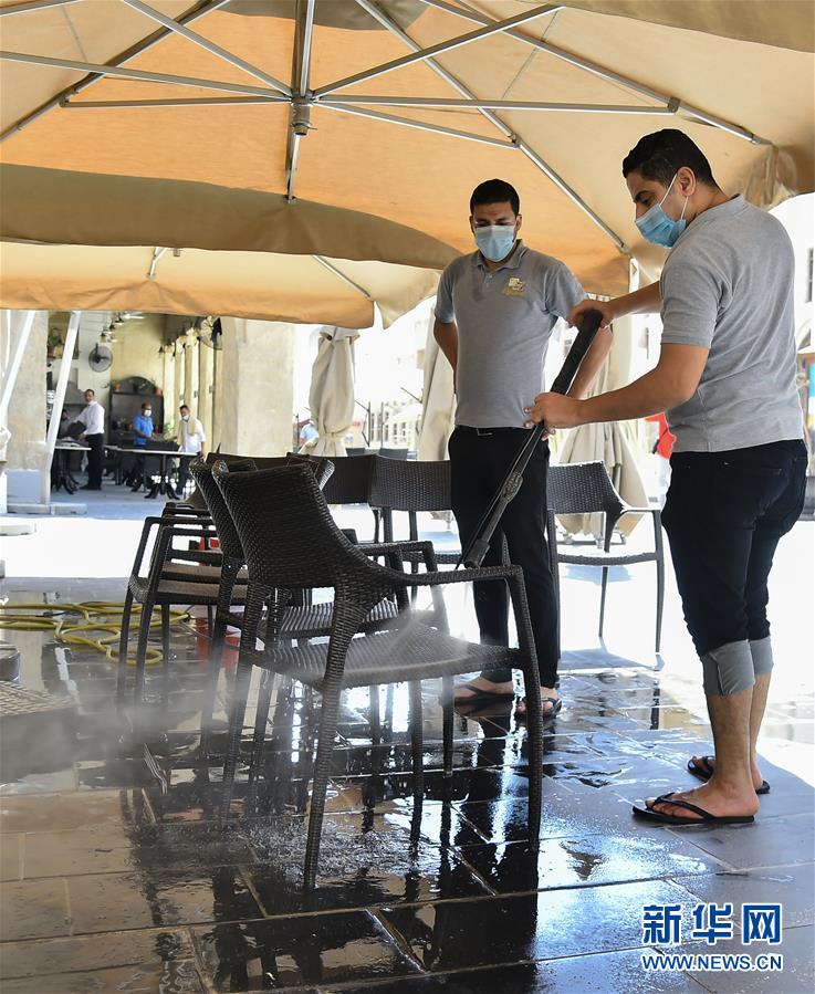 7月1日，工作人员在卡塔尔多哈的一家饭店清洁座椅。 卡塔尔7月1日起进入解除部分防控措施第二阶段，允许部分商场、自由市场、餐馆恢复营业，要求入内者必须佩戴口罩、出示健康码和检测体温。卡塔尔卫生部同日宣布，该国当日报告新增确诊病例915例，累计确诊97003例。卡卫生部指出，随着第二阶段解除部分防疫限制措施的深入，卡塔尔防疫面临的压力将会增大，强化防疫工作越发重要，任何疏于防疫的行为都有可能导致疫情反弹。 新华社发（尼库摄）