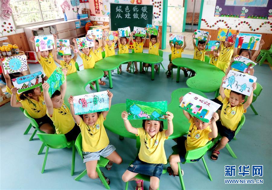 7月2日，湖南省涟源市桥头河镇新培童心幼儿园的小朋友展示手绘的低碳环保作品。 当日是第8个全国低碳日，主题是“绿色低碳、全面小康”。各地开展形式多样的主题活动，倡导低碳环保的绿色生活方式。 新华社发（张扬摄）