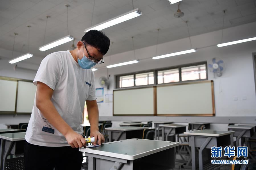 7月3日，一名老师在天津中学考场粘贴座号。2020年全国高考即将拉开帷幕，各地精心做好各项准备工作。 新华社记者 李然 摄