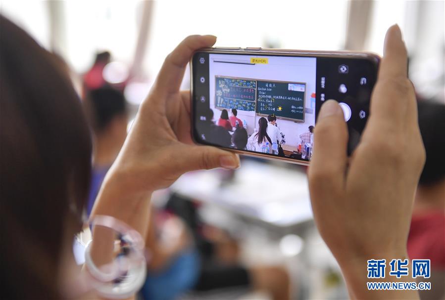 7月6日，吉林省孤儿学校高三年级班主任吴东辉用手机拍摄学生们写给她的“请假条”。 新华社记者 许畅 摄