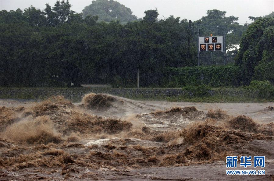 这是7月7日在日本九州地区拍摄的筑后川部分河段，远处的电子屏上显示水库紧急泄洪的通知。 受停滞的梅雨锋面影响，日本九州地区北部7日继续遭遇强降雨天气。迄今，九州因暴雨引发的洪水泛滥、山体滑坡造成的死亡人数升至55人，另有13人失踪。 新华社/共同社