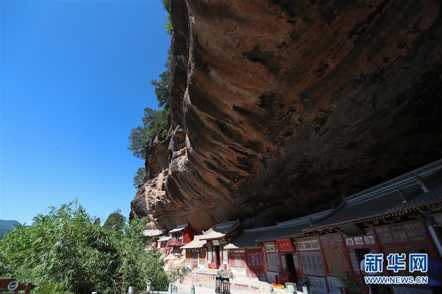 这是7月7日拍摄的甘肃省天水市麦积山风景区仙人崖一景。 位于甘肃省天水市麦积山风景区的仙人崖古树郁郁葱葱，水色静谧秀美。这里夏季气候凉爽，不少游客前来避暑乘凉。 新华社发（马希平 摄）