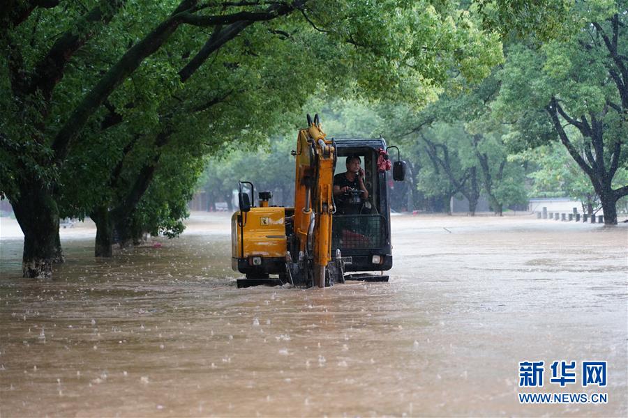 7月8日，在南昌市湾里管理局招贤镇，工程车行驶在被淹的街道上。 近日，江西南昌遭遇持续强降雨天气，当地政府抓紧组织开展抢险救援工作。 新华社记者 周密 摄