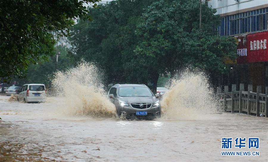 7月8日，在南昌市湾里管理局招贤镇，汽车通过被淹街道。 近日，江西南昌遭遇持续强降雨天气，当地政府抓紧组织开展抢险救援工作。 新华社记者 周密 摄