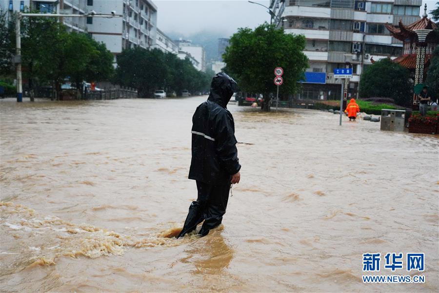 7月8日，在南昌市湾里管理局招贤镇，市民行走在被淹的街道上。 近日，江西南昌遭遇持续强降雨天气，当地政府抓紧组织开展抢险救援工作。 新华社记者 周密 摄