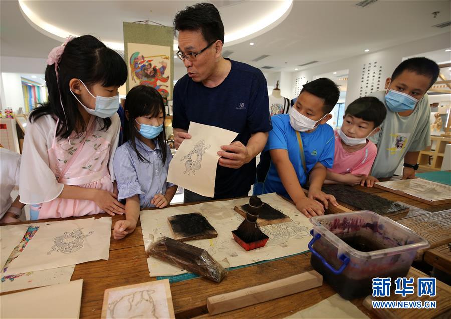 7月8日，山东省潍坊市潍城区城关街道十笏园社区的小朋友在了解木版年画的印制。 当日，山东省潍坊市潍城区城关街道十笏园社区开展了“暑假学‘非遗’”活动，组织社区内放暑假的孩子到十笏园文化街区现场体验了解潍坊风筝、木版年画、传统花灯等非遗项目的制作工艺过程，感受家乡传统民间文化的魅力，乐享假期。 新华社发（张驰 摄）