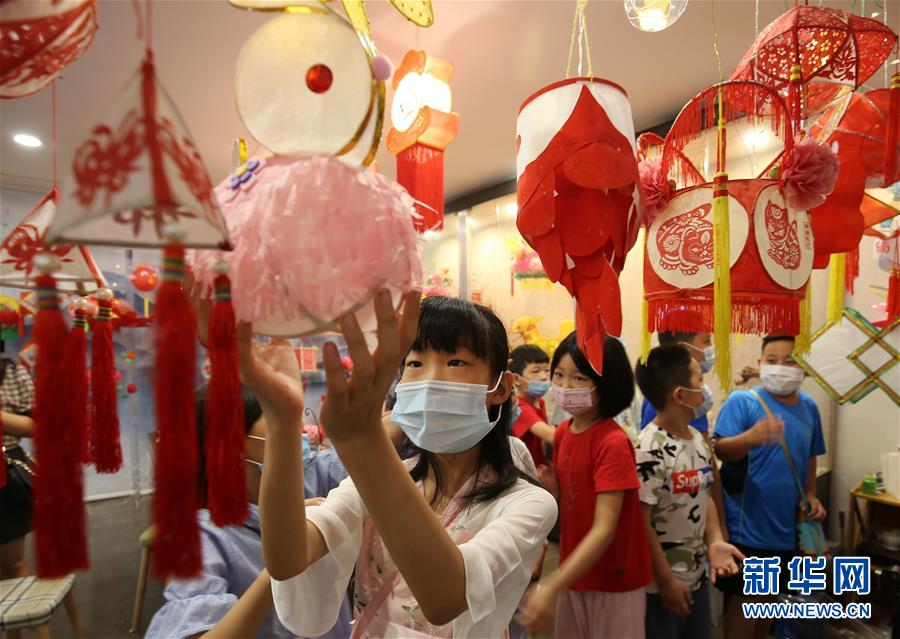 7月8日，山东省潍坊市潍城区城关街道十笏园社区的小朋友被各式各样的传统花灯吸引。 新华社发（张驰 摄）