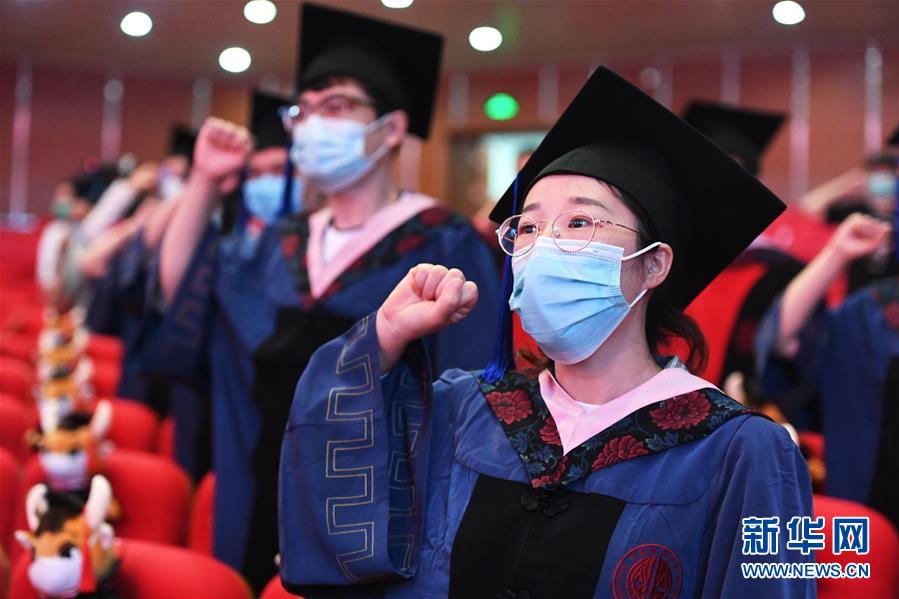 7月10日，中国政法大学2020届毕业生在毕业典礼上重温入学誓词。 当日，中国政法大学举行2020届毕业典礼。由于疫情防控需要，仅少量在校毕业生在中国政法大学昌平校区礼堂现场参加毕业典礼，更多毕业生通过线上直播参与。 新华社记者 任超 摄