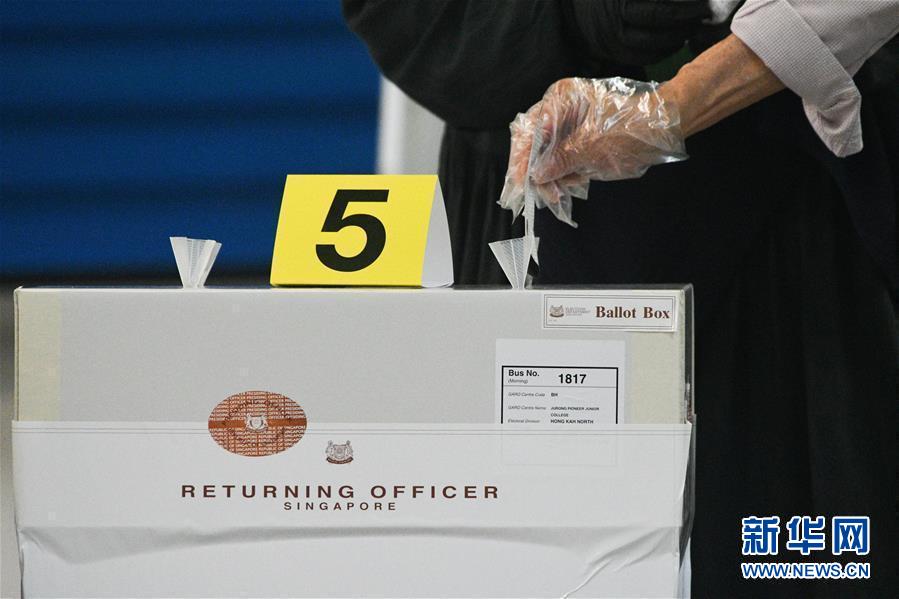 7月10日，一名戴手套的选民在新加坡一处投票站投票。 新加坡当日举行第13届国会选举。 新华社发（邓智炜摄）