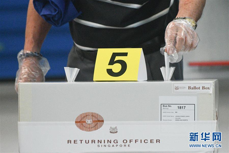7月10日，戴着手套的新加坡选民在一处投票站投票。 新加坡当日举行第13届国会选举。 新华社发 （邓智炜摄）