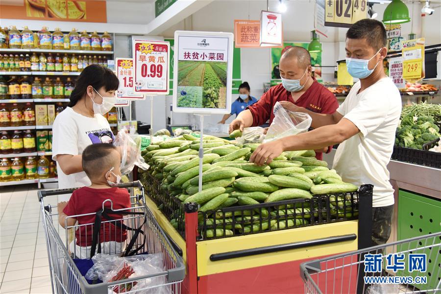 7月9日，顾客在黑龙江省林甸县比优特超市挑选“小菜园”蔬菜。 地处大兴安岭南麓集中连片特困地区的黑龙江省林甸县，近年把发展庭院经济作为促进贫困群众脱贫增收的重要路径，引导鼓励农民在自家“小菜园”发展特色种植、养殖，将“小菜园”变成“增收田”。目前，全县共落实庭院种养殖14000余户，其中贫困户3000余户。 新华社记者 程子龙 摄