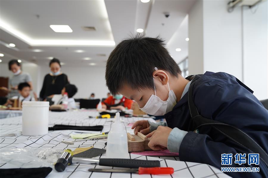 7月15日，小朋友在“大国小工匠”技能体验活动上体验制作拇指琴。 当日，“大国小工匠”技能体验活动在中国（上海）创业者公共实训基地举行。该活动是7·15世界青年技能日主题系列活动之一。 新华社记者 滕佳妮 摄