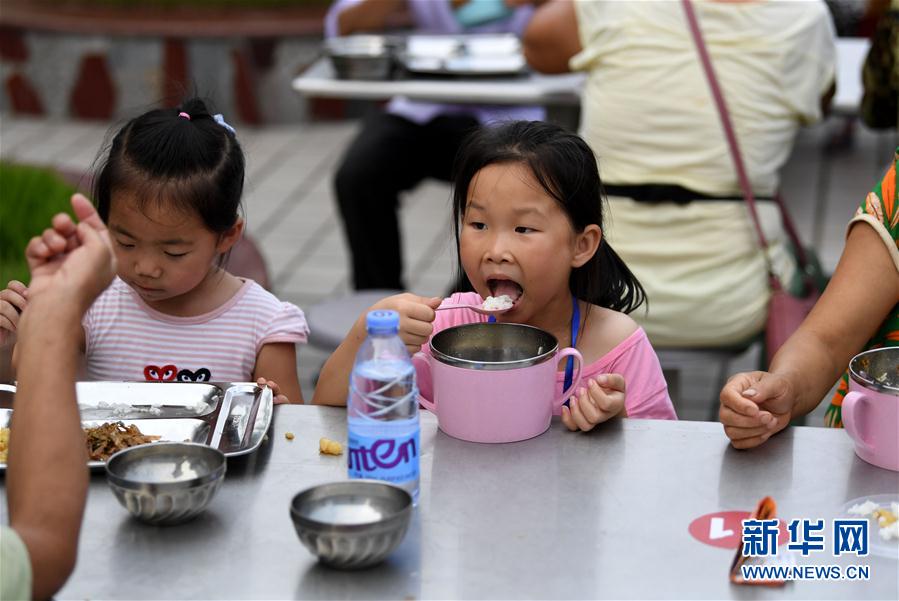 7月14日，在安徽省宿松县洲头乡中心小学集中安置点，小朋友在吃晚餐。 新华社记者 刘军喜 摄
