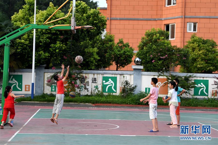 7月14日，在安徽省宿松县洲头乡中心小学集中安置点，小朋友们在打篮球。 新华社记者 刘军喜 摄