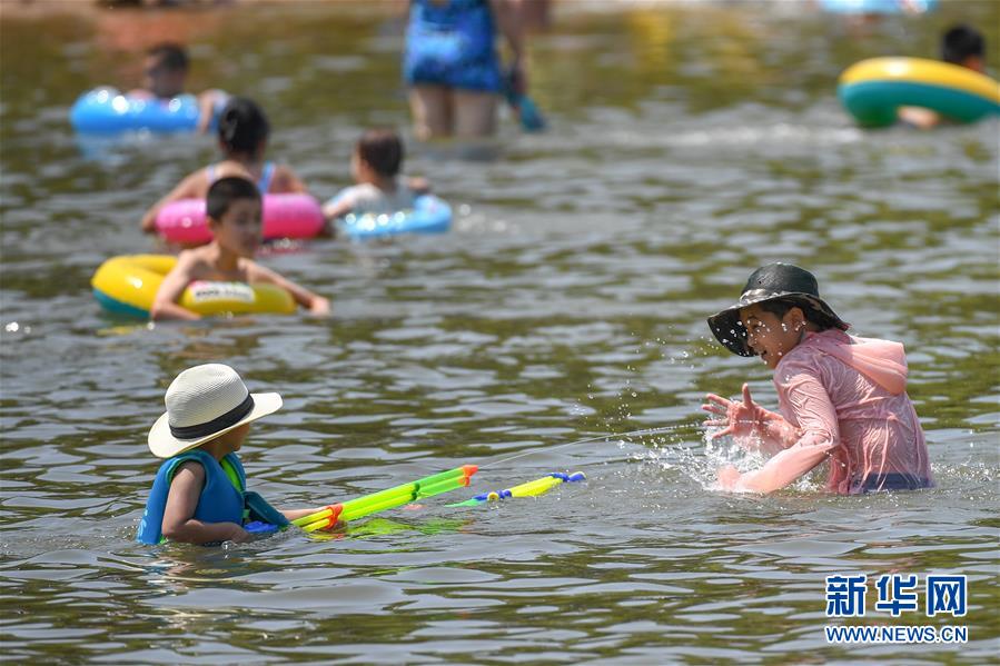 7月16日，小朋友在长春南湖公园沙滩浴场戏水。 当日是“头伏”首日，吉林长春最高气温达33℃，众多市民来到南湖公园乘凉避暑。 新华社记者 张楠 摄