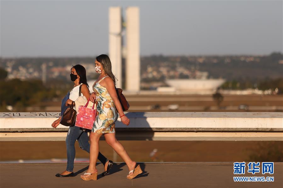 7月16日，巴西首都巴西利亚居民戴口罩出行。 根据巴西卫生部16日公布的数据，巴西新冠确诊病例累计超过200万例。 新华社发（卢西奥·塔沃拉摄）