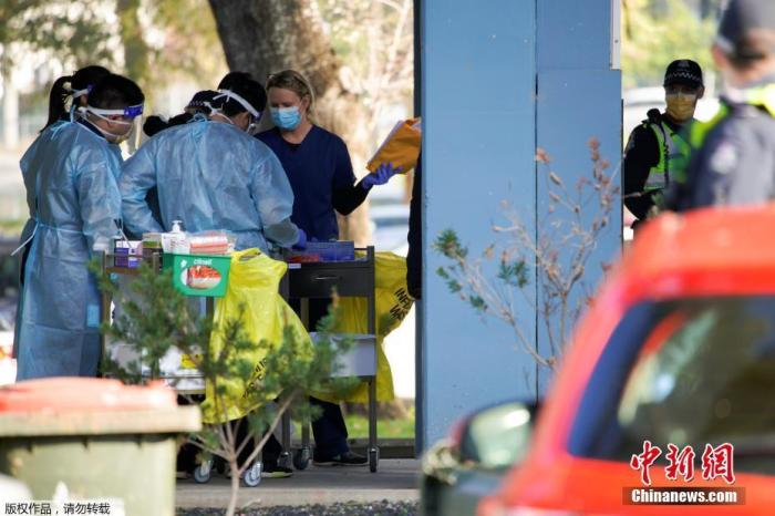 当地时间7月8日,澳大利亚墨尔本,为应对新冠状病毒病的爆发,工作人员在公共住宅大楼外参加简报会。 点击进入下一页