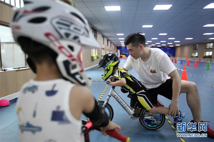 7月19日，在南京一家滑步车俱乐部里，教练为孩子矫正动作。 暑假期间，小朋友们通过多种方式学习知识、强健体魄，丰富暑期生活。 新华社发 （孙忠南 摄）
