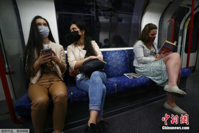 当地时间6月15日,英国伦敦,乘客戴口罩乘坐地铁出行。 点击进入下一页