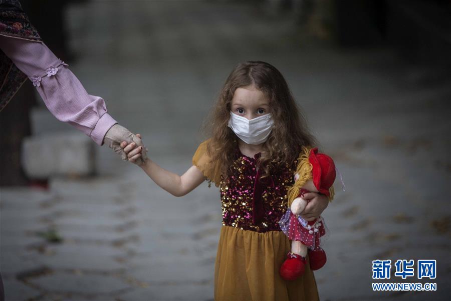 7月22日，一名女孩戴着口罩走在伊朗马里万街头。 伊朗卫生部22日宣布，当日新增新冠确诊病例2586例，累计确诊281413例，累计死亡14853例。 新华社发（艾哈迈德·哈拉比萨斯摄）