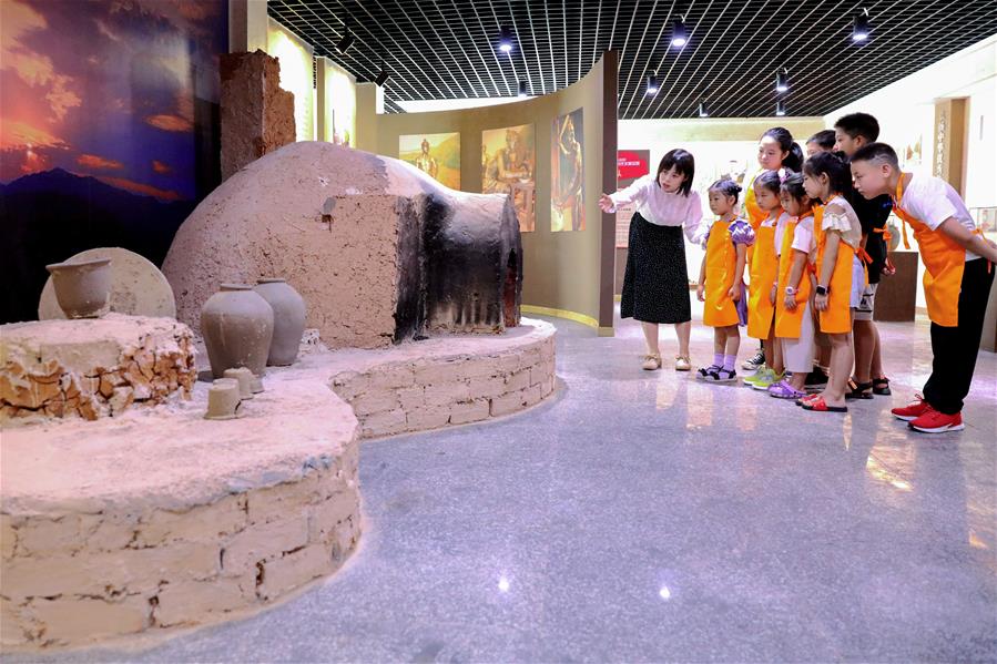 7月24日，在长兴县林城镇方山窑村，孩子们在青年志愿者的带领下参观当地窑址展览馆。新华社记者 徐昱 摄