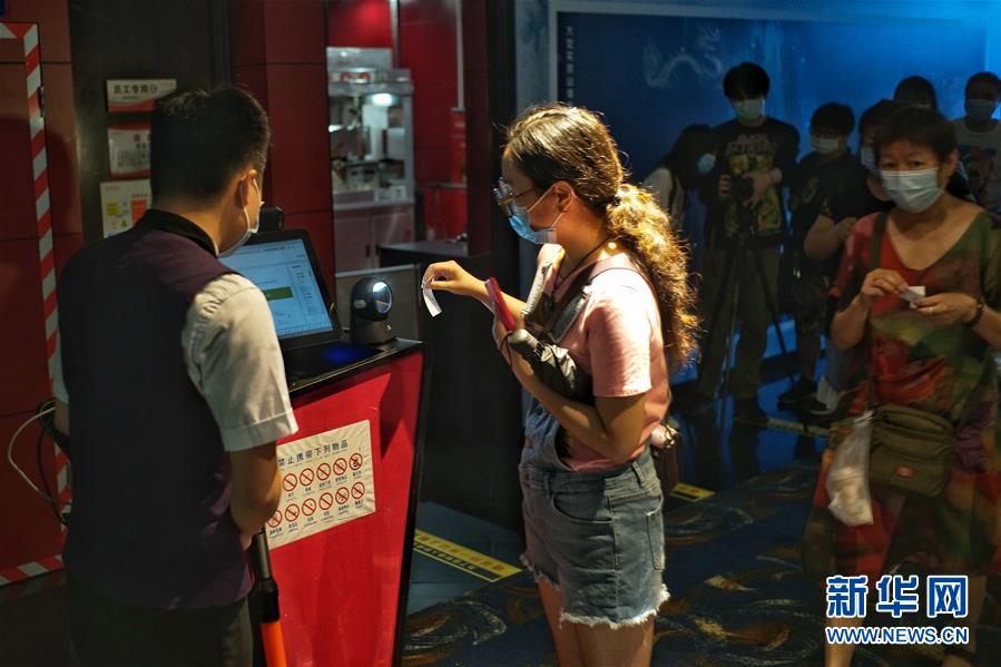 7月24日，在首都电影院（西单店），市民排队验票进入影厅。 当日，在做好新冠肺炎疫情防控的前提下，北京市部分电影院有序恢复开放。 新华社记者 彭子洋 摄