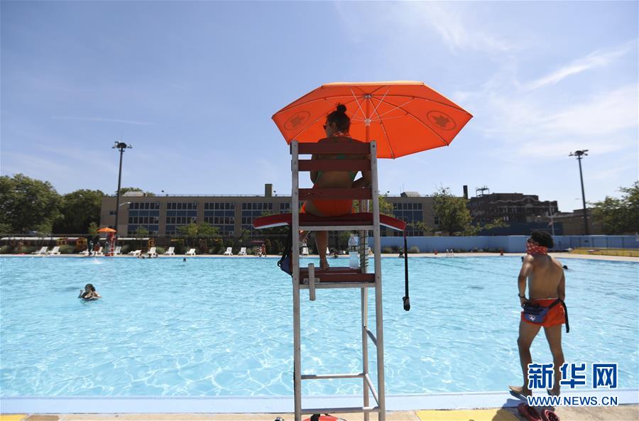 7月27日，救生员在美国纽约一处公共泳池值班。 当天，纽约市最高气温超过36摄氏度，刚刚开放的户外泳池成为人们消暑的好去处。 新华社记者王迎摄