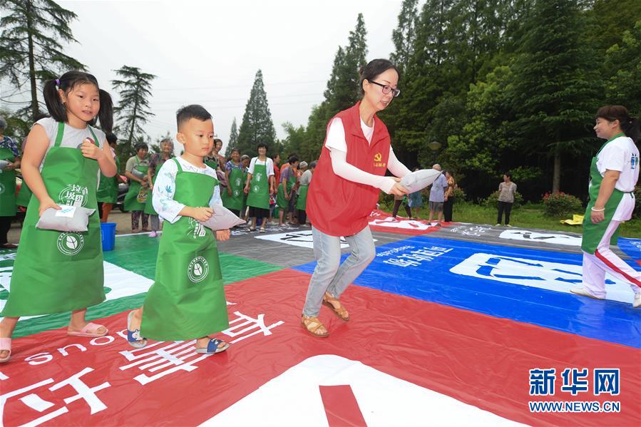 7月28日，在湖州吴兴区埭溪镇盛家坞村，志愿者带领村民参加垃圾分类趣味游戏。 近年来，浙江省湖州市在“两山”理念指导下探索适合乡村特点的垃圾分类长效机制，在青山绿水间践行现代文明理念和绿色生活方式，建设生态宜居的美丽乡村。 新华社记者翁忻旸摄