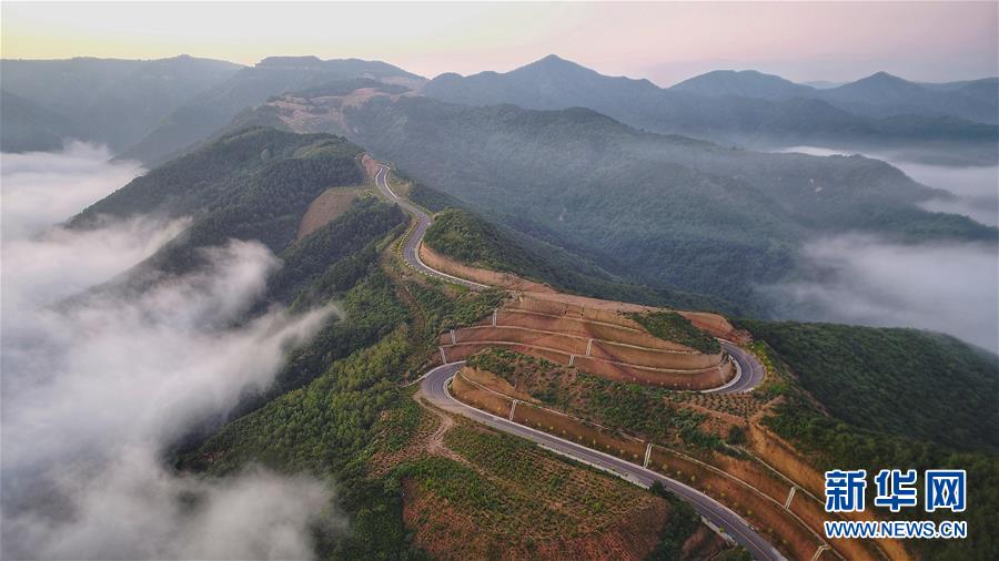 7月28日拍摄的凤翅山至蟒头山国家森林公园全域旅游示范路（无人机照片）。 位于陕西省延安市宜川县凤翅山至蟒头山国家森林公园间的全域旅游示范路沿途风景优美，时常可见翻腾的云海。示范路方便旅客观赏沿线丛林山水，也辐射带动了沿线3个贫困村的村民脱贫致富。 新华社发（赵洁 摄）