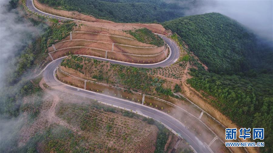 7月28日拍摄的凤翅山至蟒头山国家森林公园全域旅游示范路（无人机照片）。 位于陕西省延安市宜川县凤翅山至蟒头山国家森林公园间的全域旅游示范路沿途风景优美，时常可见翻腾的云海。示范路方便旅客观赏沿线丛林山水，也辐射带动了沿线3个贫困村的村民脱贫致富。 新华社发（赵洁 摄）