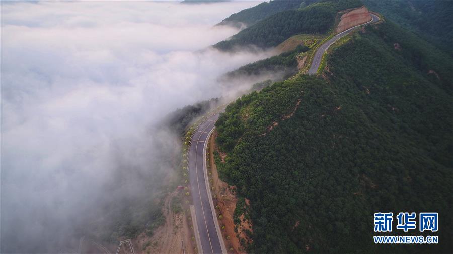 7月28日拍摄的凤翅山至蟒头山国家森林公园全域旅游示范路（无人机照片）。 位于陕西省延安市宜川县凤翅山至蟒头山国家森林公园间的全域旅游示范路沿途风景优美，时常可见翻腾的云海。示范路方便旅客观赏沿线丛林山水，也辐射带动了沿线3个贫困村的村民脱贫致富。 新华社发（赵洁 摄）