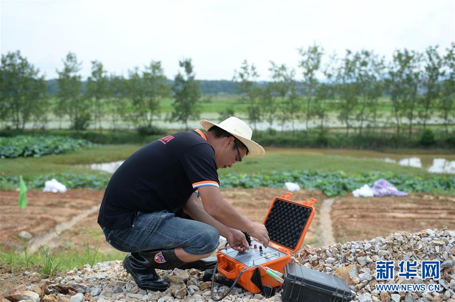 7月28日，在临湘市聂市镇毛湾垸，工作人员在调试检测仪。新华社发（陈振海摄）