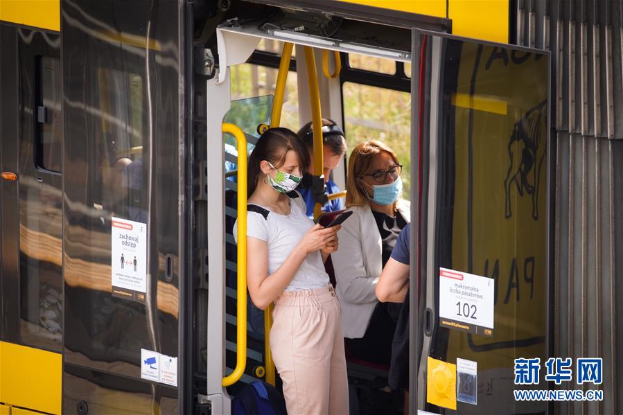 7月27日，人们戴着口罩在波兰华沙乘坐电车。新华社发（亚普·阿林摄）