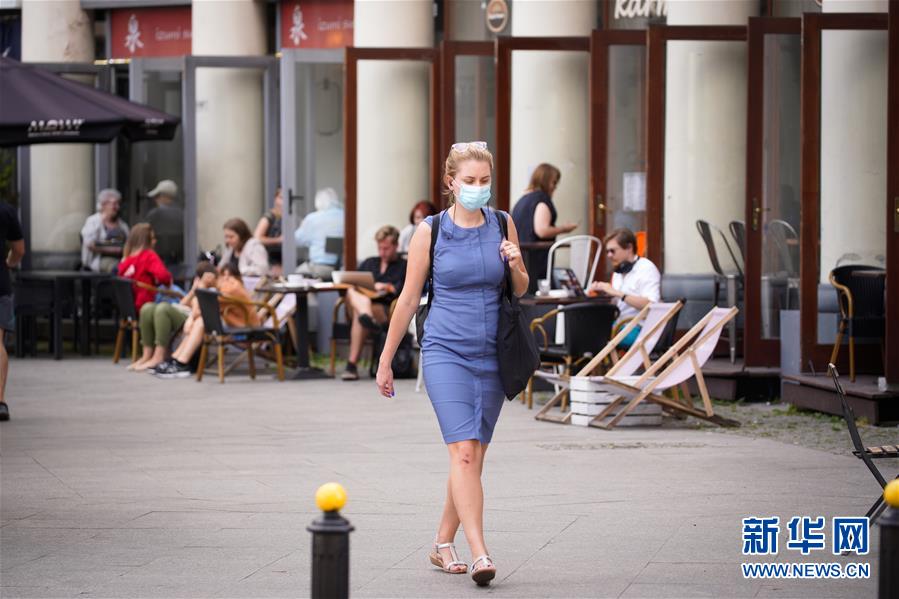7月27日，一名戴口罩的女子走在波兰华沙的街道上。新华社发（亚普·阿林摄）