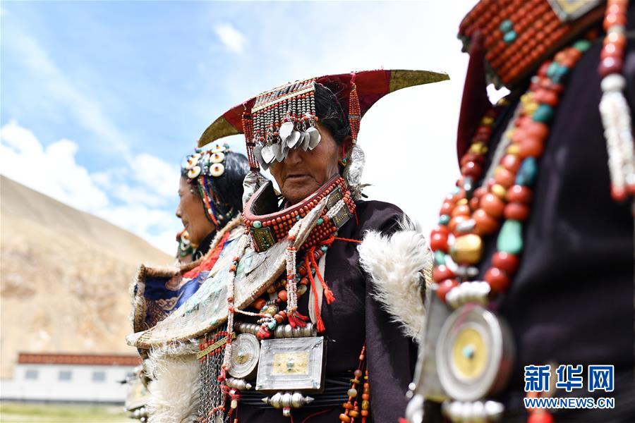 在西藏阿里地区普兰县科迦村，村民在展示普兰服饰（7月28日摄）。 在西藏阿里地区普兰县，至今保留着独特的藏族服饰——普兰服饰。据了解，普兰服饰已有1000多年的历史，其中最精美、最独特的是妇女的“孔雀”服饰，一套重达20多公斤，装饰有黄金、白银、蜜蜡、珊瑚、绿松石等，堪称“穿在身上的千年历史”。 新华社记者 詹彦 摄