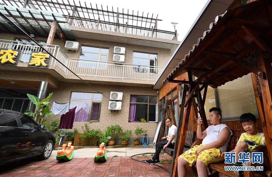 7月29日，在天津市蓟州区下营镇小平安村，游人在一家农家乐内休憩。新华社记者 李然 摄