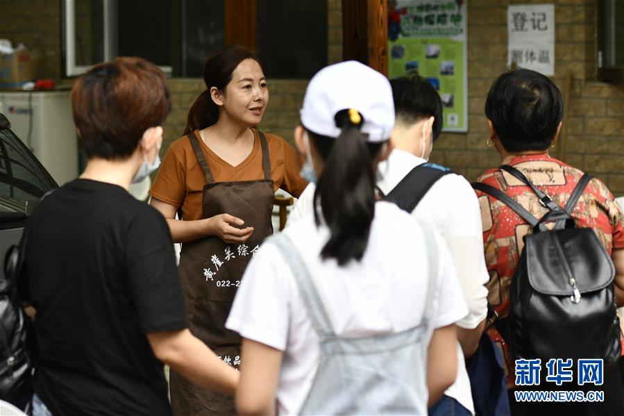 7月29日，在天津市蓟州区下营镇小平安村，经营农家乐的村民（左二）在迎接游人。新华社记者 李然 摄