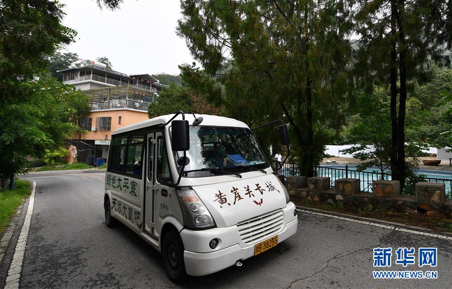 7月29日，在天津市蓟州区下营镇小平安村，黄崖关长城景区的车辆从一家农家乐门口经过。新华社记者 李然 摄