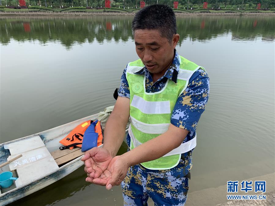 李代国在龙溪河畔检查水质（7月25日摄）。新华社记者 周闻韬 摄